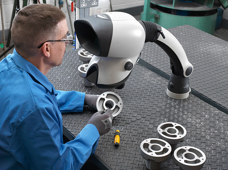 02-Mantis-stereo-microscope-versatile-workshop-application-768x572px man in blue coat deburring metal part using Mantis stereo microscope