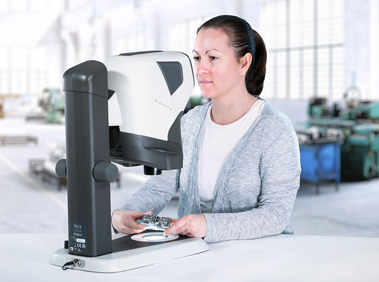 Woman inspecting metal part using Mantis on Stabila stand